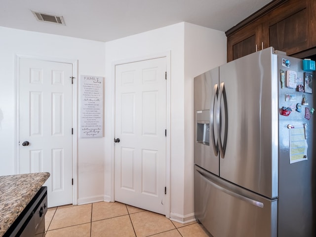 kitchen featuring light tile patterned floors, dishwashing machine, dark brown cabinetry, and stainless steel fridge with ice dispenser