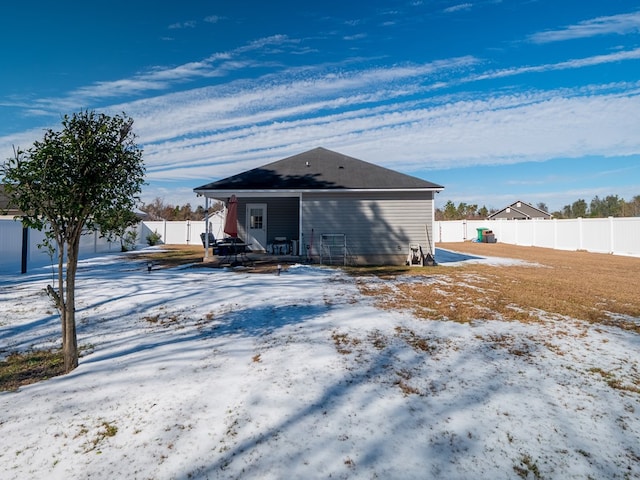 view of snow covered rear of property