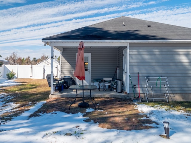 view of snow covered back of property