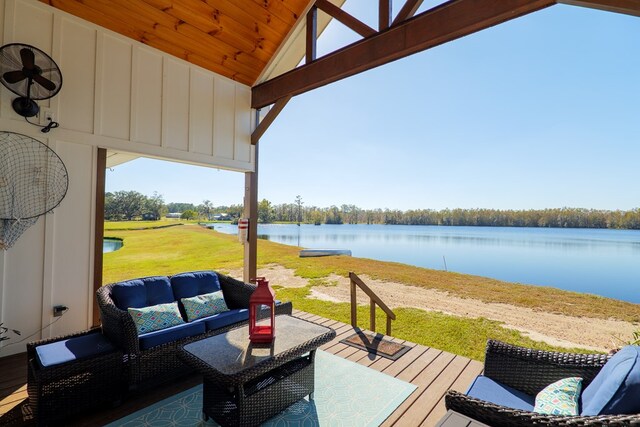 wooden terrace with a water view and an outdoor hangout area