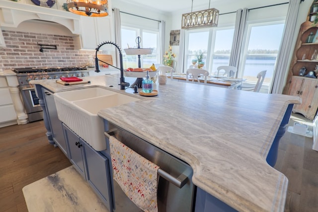 kitchen with pendant lighting, white cabinets, a water view, dark hardwood / wood-style flooring, and stainless steel appliances