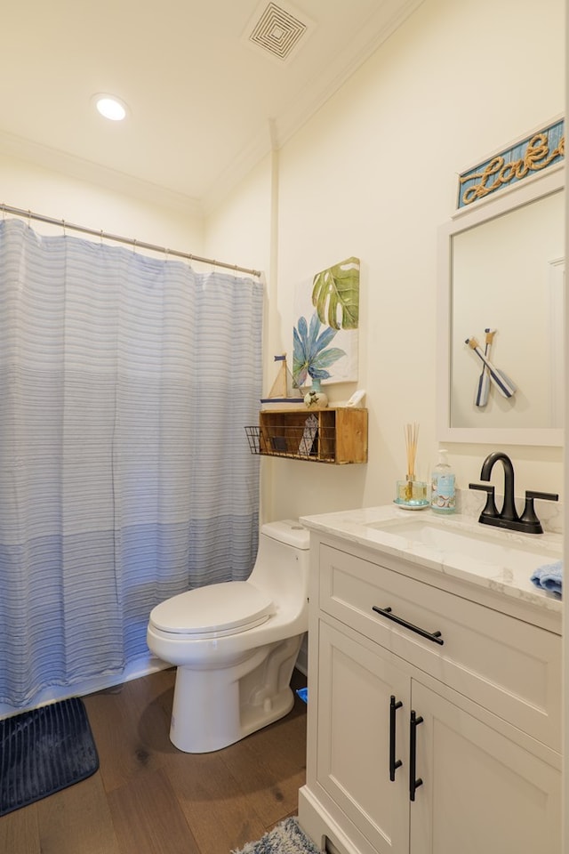 bathroom featuring vanity, toilet, wood-type flooring, and ornamental molding