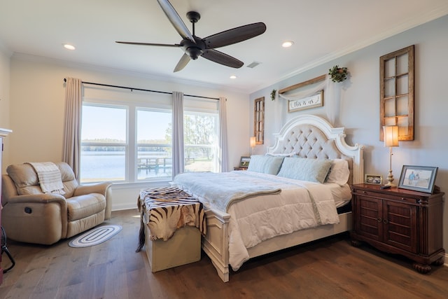 bedroom featuring dark hardwood / wood-style flooring, a water view, ceiling fan, and ornamental molding