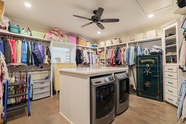 laundry area featuring washing machine and clothes dryer, ceiling fan, crown molding, and light wood-type flooring