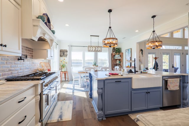 kitchen with white cabinets, appliances with stainless steel finishes, french doors, and hanging light fixtures