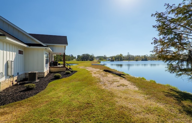 view of yard featuring central air condition unit and a water view