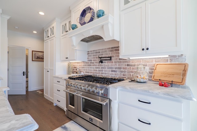 kitchen with dark hardwood / wood-style flooring, tasteful backsplash, light stone counters, range with two ovens, and white cabinetry