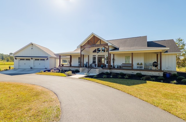 view of front of house featuring a front yard, a porch, and a garage