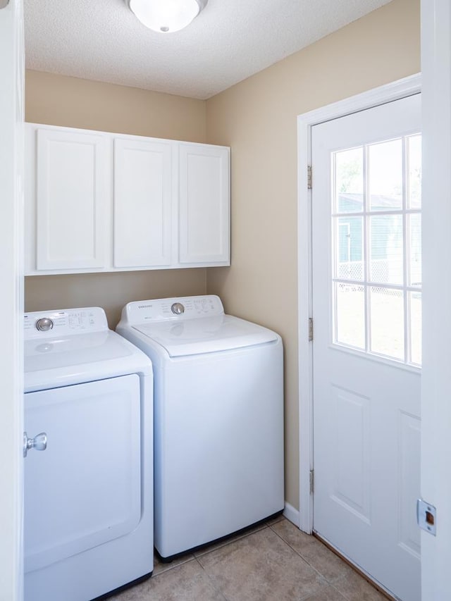 3875 Studstill Rd, Valdosta, GA 31605 - washroom with washing machine and clothes dryer, cabinet space, light tile patterned floors, and a textured ceiling