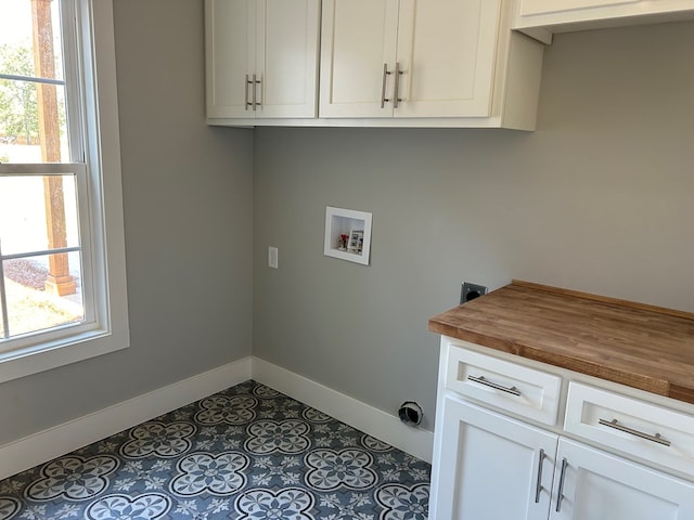 clothes washing area with cabinets, washer hookup, and tile patterned flooring