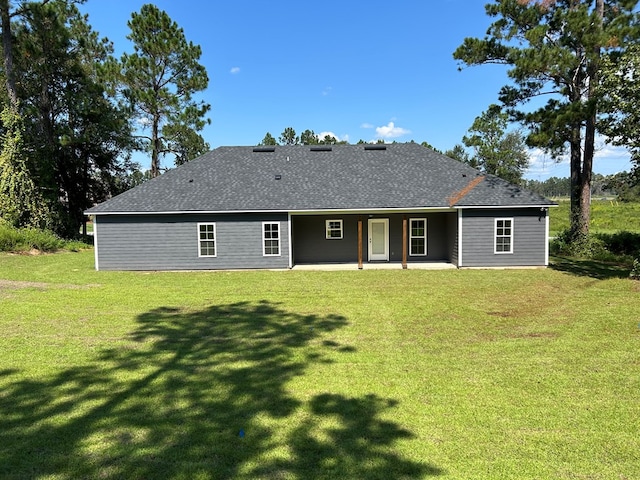 rear view of house featuring a patio area and a lawn