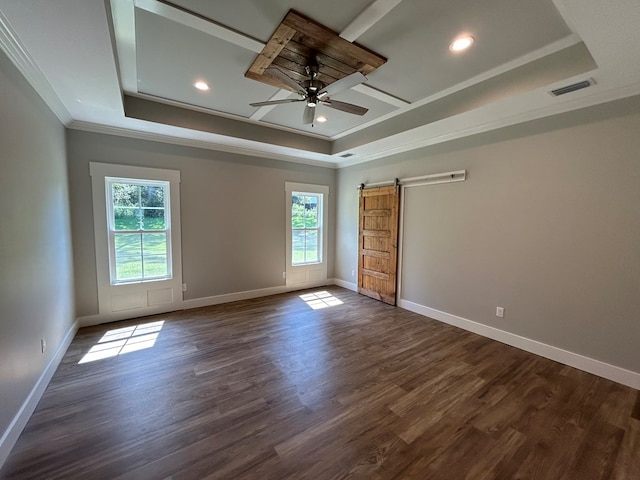 unfurnished room with ceiling fan, a barn door, ornamental molding, a tray ceiling, and dark hardwood / wood-style flooring