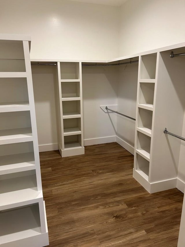 walk in closet with dark hardwood / wood-style flooring