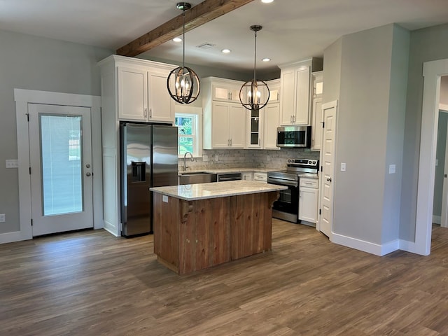 kitchen with a center island, sink, hanging light fixtures, appliances with stainless steel finishes, and white cabinetry