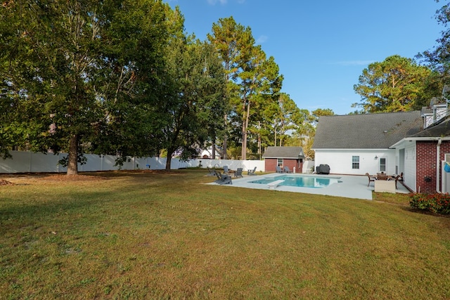 view of yard with a patio area, a fenced in pool, and an outbuilding