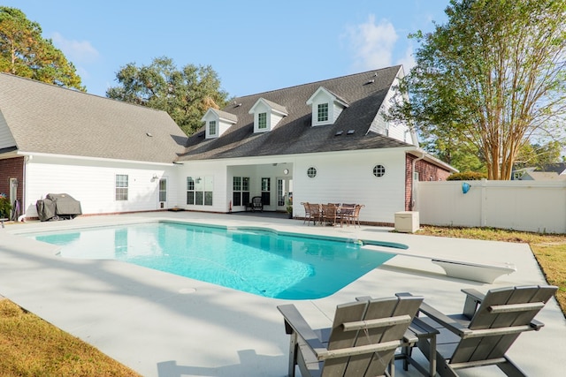 view of swimming pool featuring a diving board and a patio area