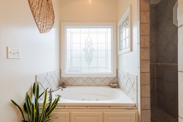 bathroom with shower with separate bathtub and plenty of natural light