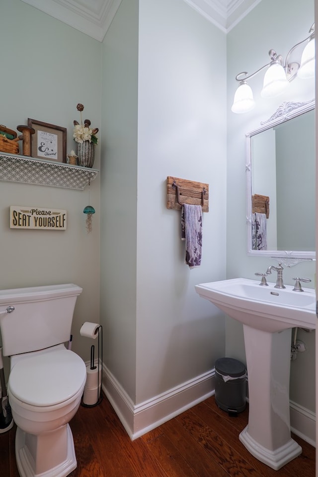 bathroom featuring sink, toilet, wood-type flooring, and ornamental molding