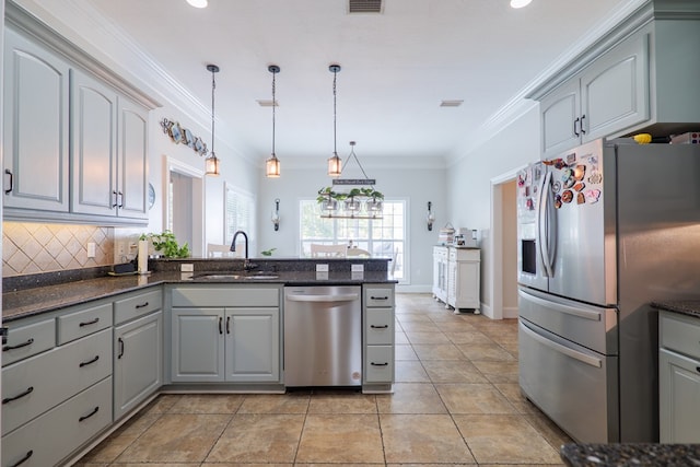 kitchen with sink, decorative light fixtures, gray cabinets, appliances with stainless steel finishes, and ornamental molding