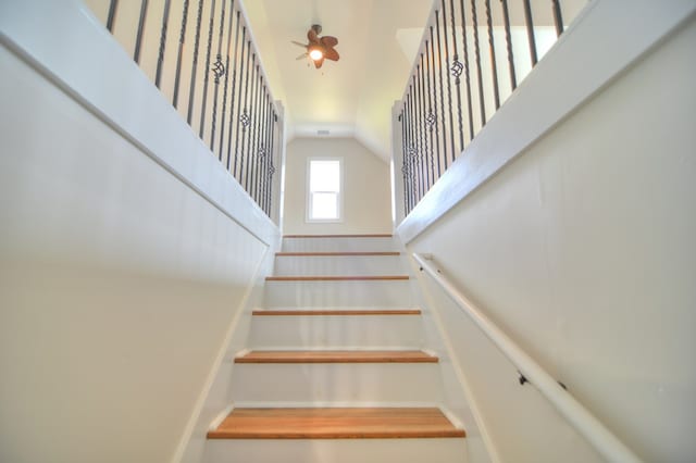 stairway featuring ceiling fan and lofted ceiling