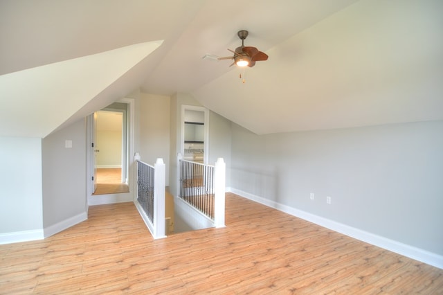 additional living space with ceiling fan, built in features, vaulted ceiling, and light wood-type flooring