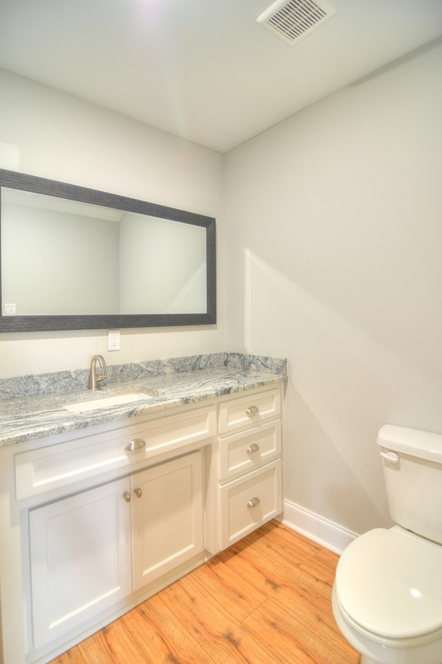 bathroom featuring hardwood / wood-style floors, vanity, and toilet