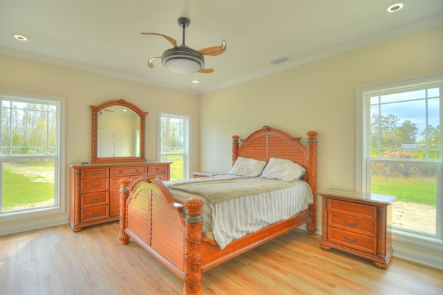 bedroom featuring ceiling fan, ornamental molding, and light wood-type flooring