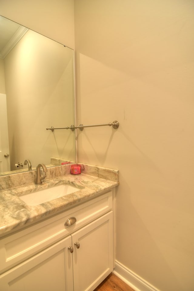 bathroom with vanity, wood-type flooring, and ornamental molding