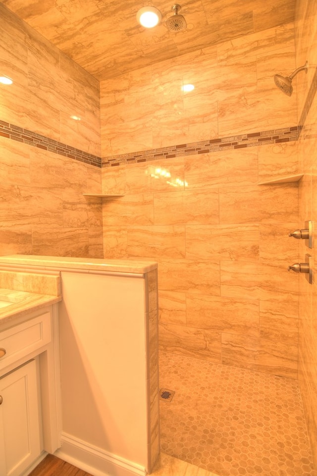 bathroom featuring a tile shower, vanity, and wood ceiling