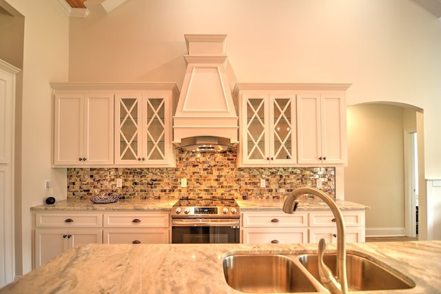 kitchen with light stone countertops, custom range hood, sink, white cabinetry, and stainless steel electric range