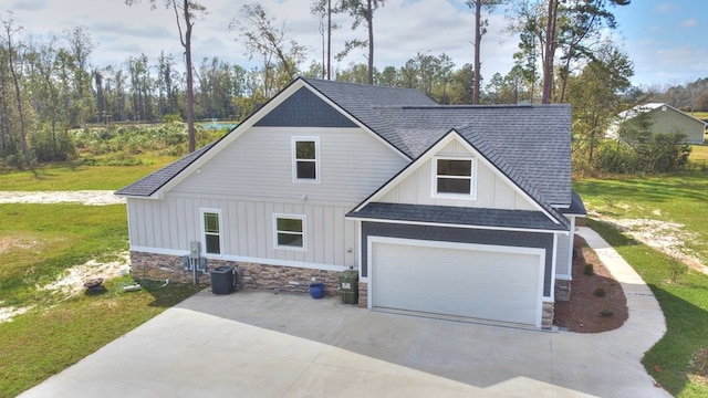 view of front facade with a front yard, central AC, and a garage