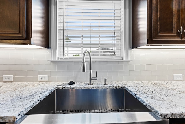4740 Amelia Cir, Hahira, GA 31632 - kitchen view of a sink, dark brown cabinets, backsplash, and light stone countertops