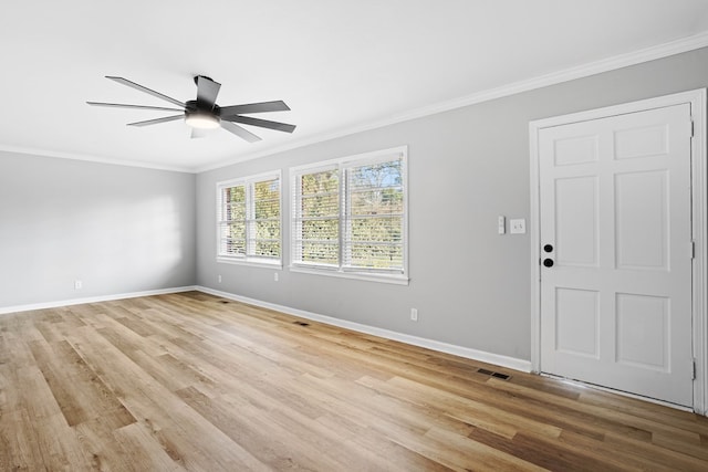 spare room featuring ornamental molding, light wood-style floors, a ceiling fan, and baseboards