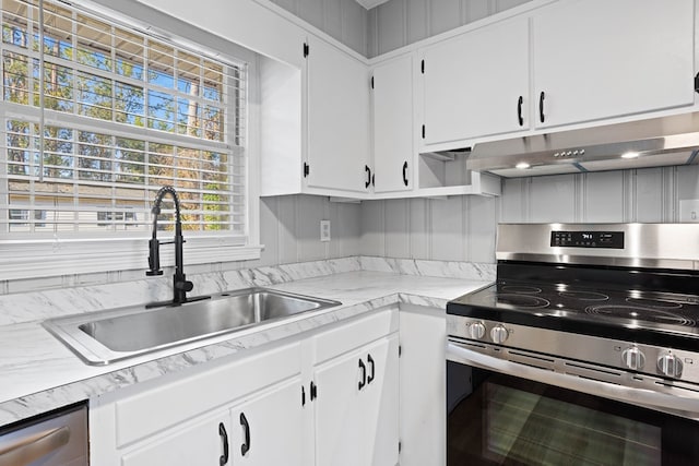 kitchen featuring light countertops, appliances with stainless steel finishes, a sink, and white cabinetry