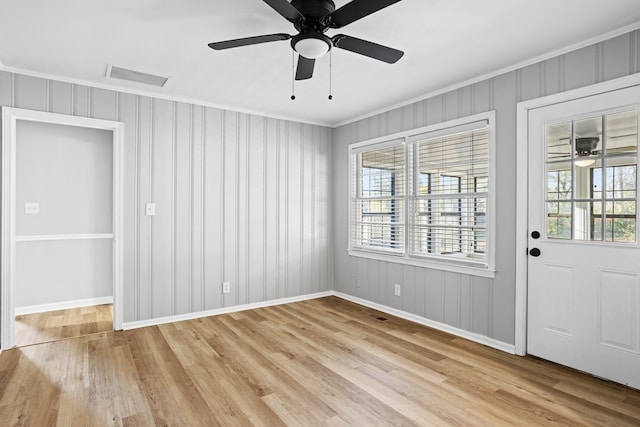 interior space featuring a healthy amount of sunlight, light wood-style flooring, visible vents, and ornamental molding