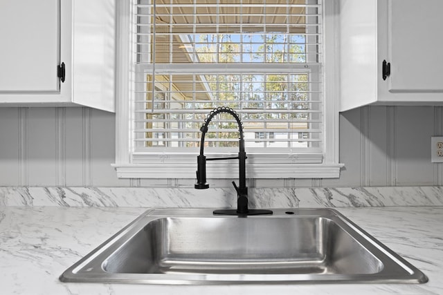 details with white cabinetry and a sink