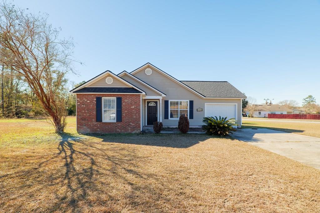 single story home featuring a garage and a front yard