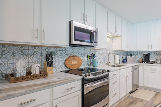 4604 Rustic Ridge Rd, Valdosta, GA 31602 - kitchen with stainless steel appliances, tasteful backsplash, white cabinetry, and light stone counters