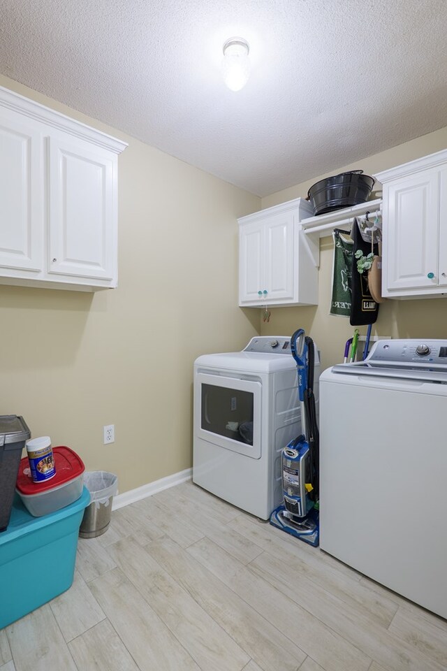 4604 Rustic Ridge Rd, Valdosta, GA 31602 - laundry area featuring washing machine and dryer, cabinet space, light wood-style floors, and a textured ceiling