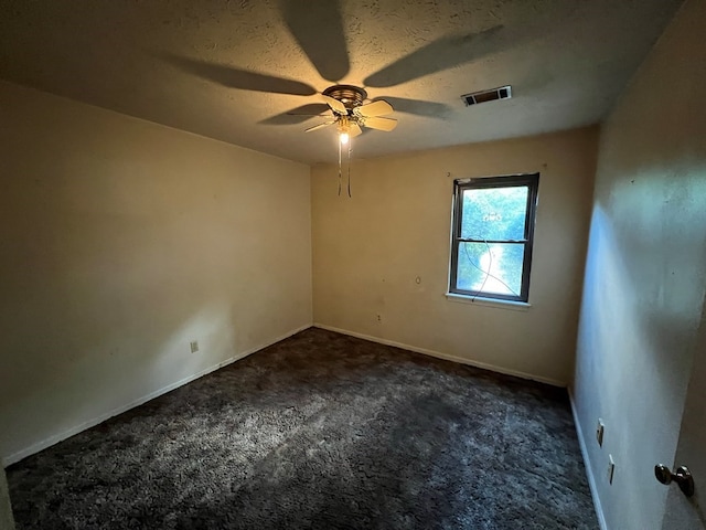 carpeted empty room featuring a textured ceiling and ceiling fan