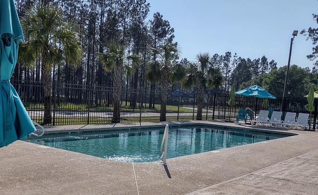 4686 Rudy Way, Hahira, GA 31632 - community pool featuring a patio area and view of wooded area