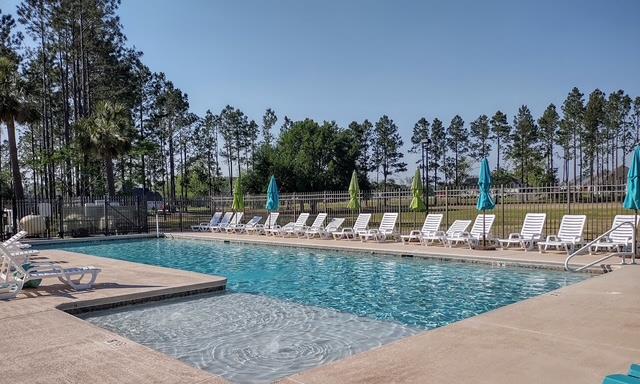 4686 Rudy Way, Hahira, GA 31632 - community pool featuring a patio area and view of wooded area