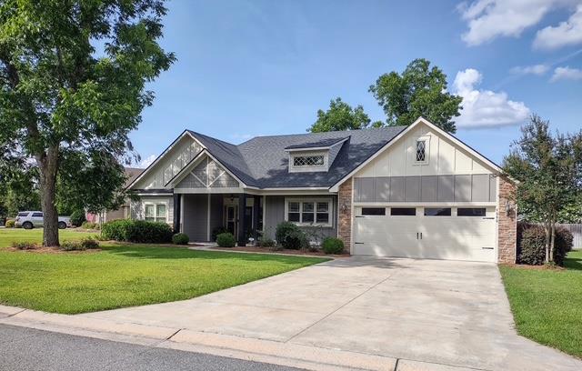 4686 Rudy Way, Hahira, GA 31632 - view of front facade with a front yard, a garage, concrete driveway, and board and batten siding