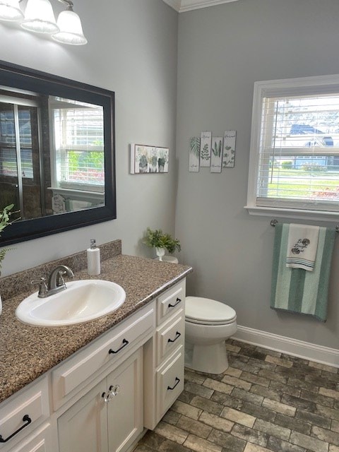 4686 Rudy Way, Hahira, GA 31632 - bathroom featuring vanity, toilet, ornamental molding, baseboards, and brick patterned floors