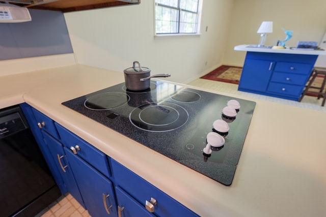 kitchen with blue cabinetry, light tile patterned flooring, and black appliances