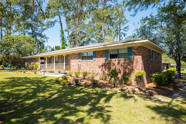 single story home featuring covered porch and a front yard