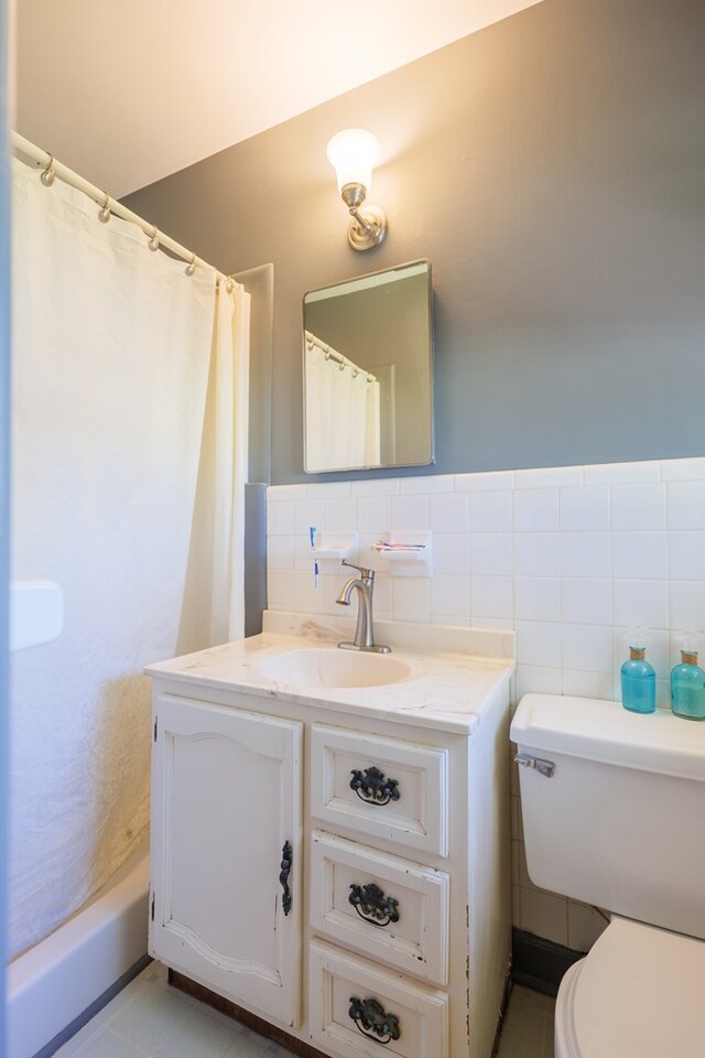 bathroom featuring vanity, a shower with shower curtain, tile walls, and toilet