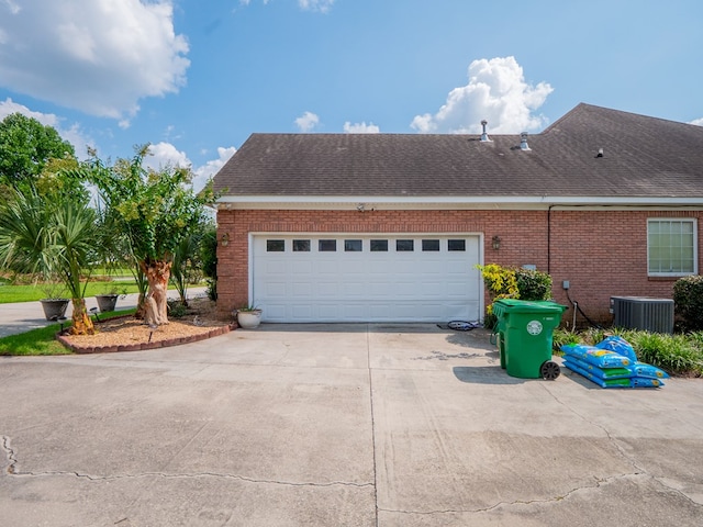 view of property exterior featuring an attached garage, central AC, a shingled roof, concrete driveway, and brick siding