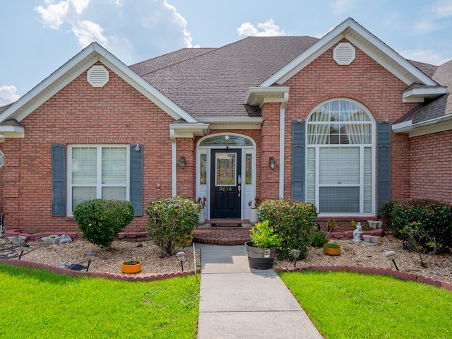 view of front of home featuring brick siding and a shingled roof