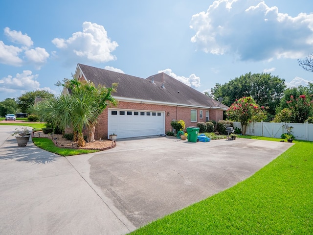 view of side of property with driveway, a gate, fence, a garage, and brick siding